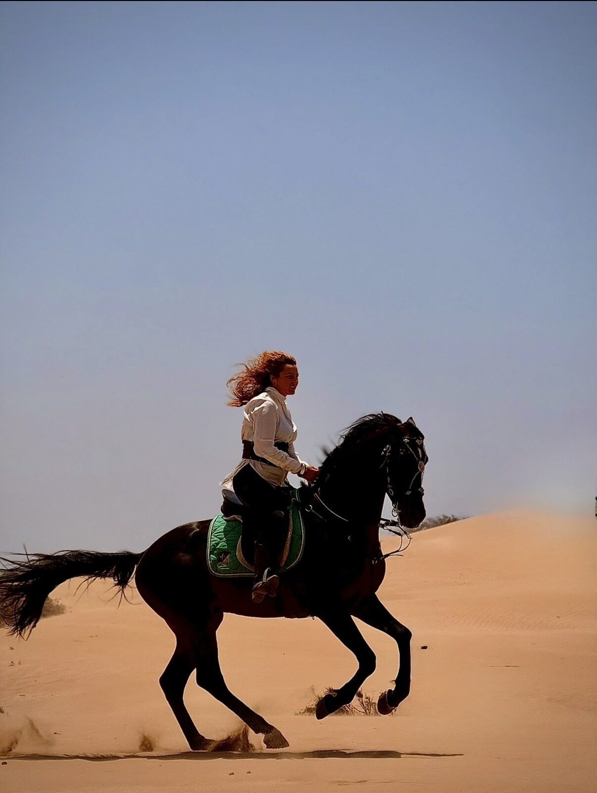 Rider galloping through the dunes