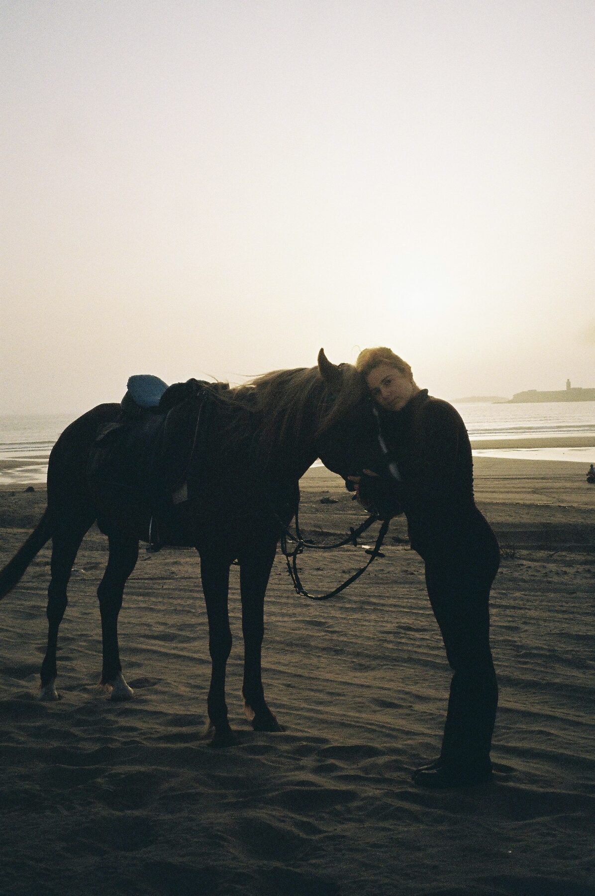 Yamina with a horse at sunset on the beach